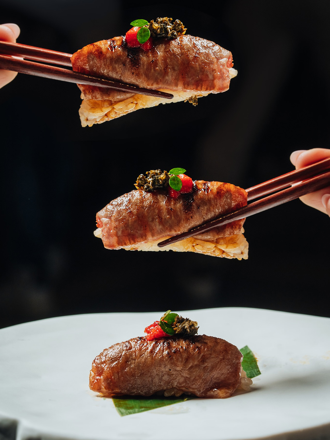 hands holding food with chopsticks